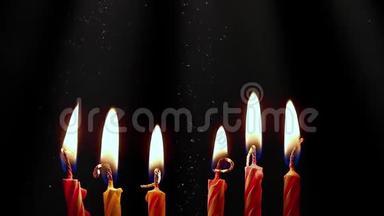 生日蜡烛在黑暗的背景上燃烧。 庆祝晚会及周年庆理念..